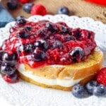 close up photo of french toast on white plate with cheesecake filling and berries