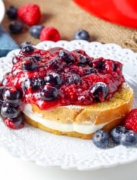 close up photo of french toast on white plate with cheesecake filling and berries