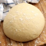 risen cinnamon roll dough on cutting board