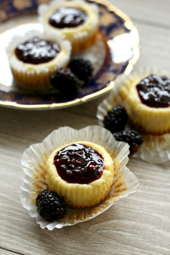 Cute mini blackberry cheesecakes made in a muffin tin with blackberry filling on top. Perfect sized portions of cheesecake to take with you for picnics, potlucks and parties. A fun summer dessert.