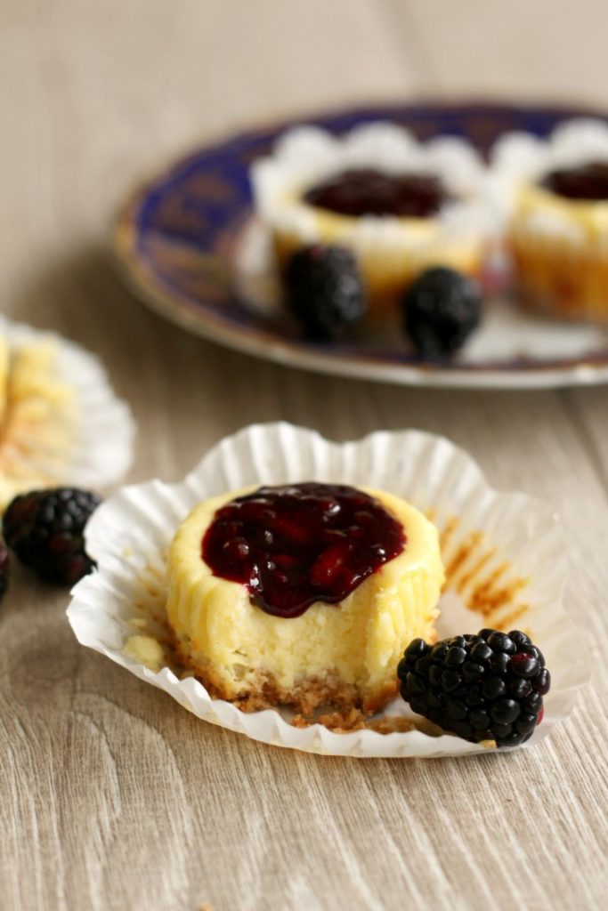 Cute mini blackberry cheesecakes made in a muffin tin with blackberry filling on top. Perfect sized portions of cheesecake to take with you for picnics, potlucks and parties. A fun summer dessert.