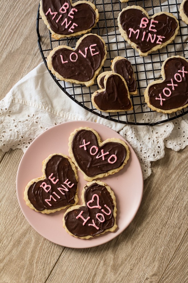 valentines day shortbread heart cookies with chocolate frosting on a pink plate