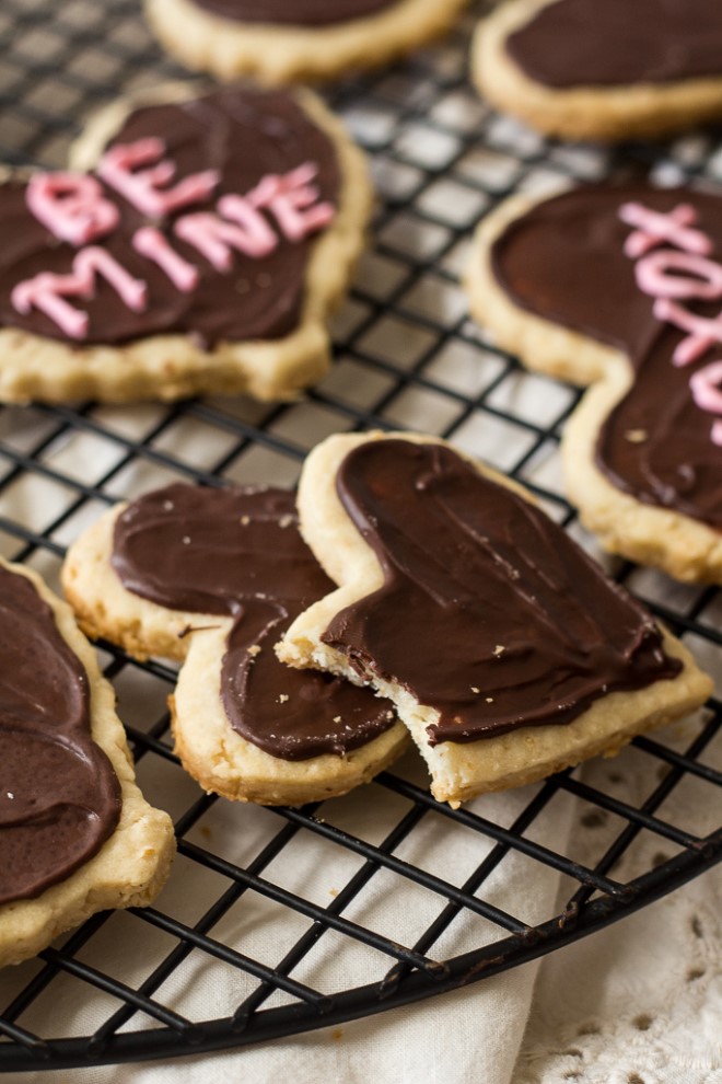 valentines day shortbread heart cookies with chocolate frosting on a cooling rack