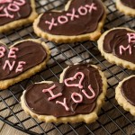 valentines day shortbread heart cookies with chocolate frosting on a cooling rack