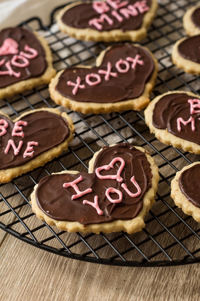 valentines day shortbread heart cookies with chocolate frosting on a cooling rack