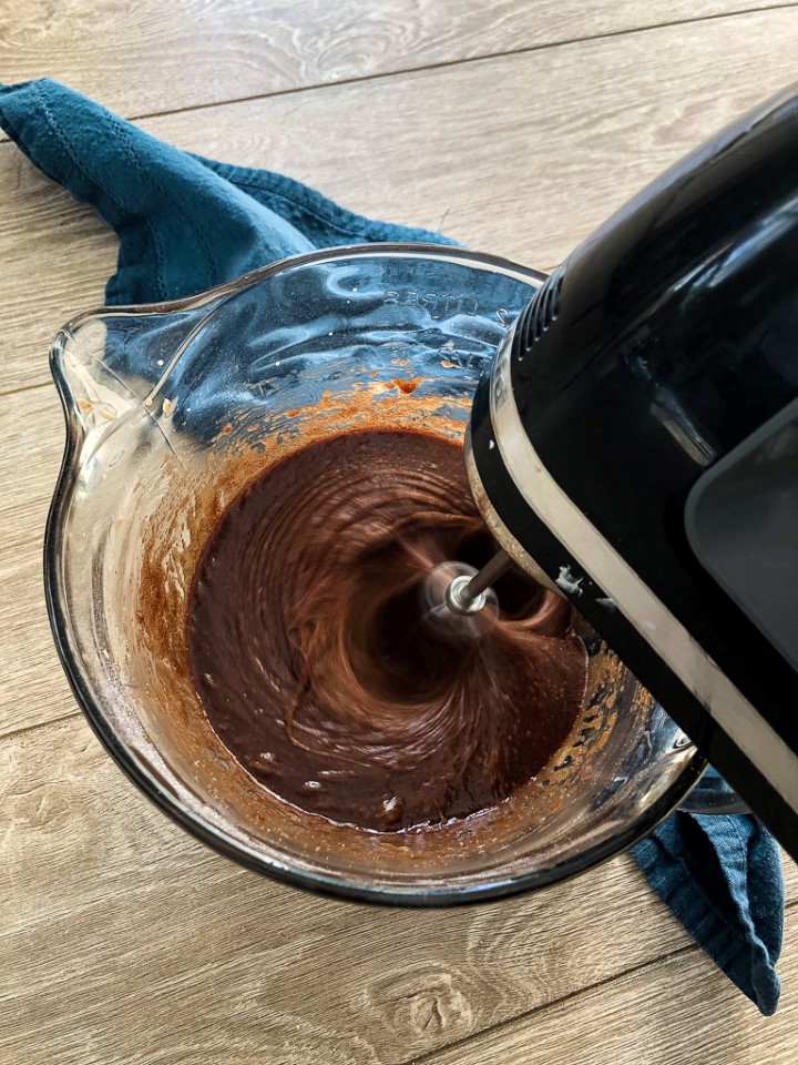 A mixer beating brownie batter