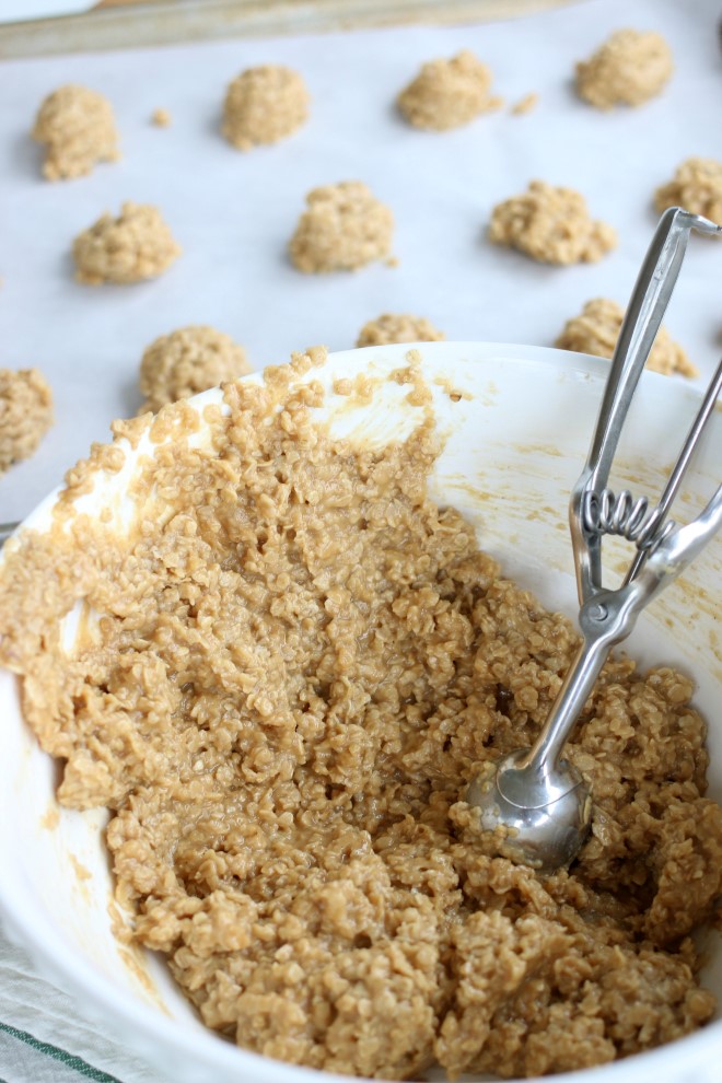 Using a cookie dough scoop to form no bake peanut butter cookies with oatmeal.