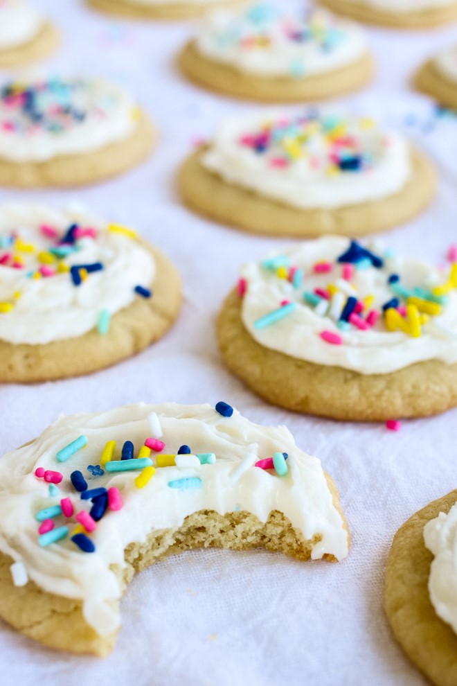 An iced sugar cookie with a bite out of it.