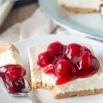 slice of cheesecake with a berry topping and a bite on a fork