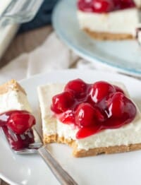 slice of cheesecake with a berry topping and a bite on a fork