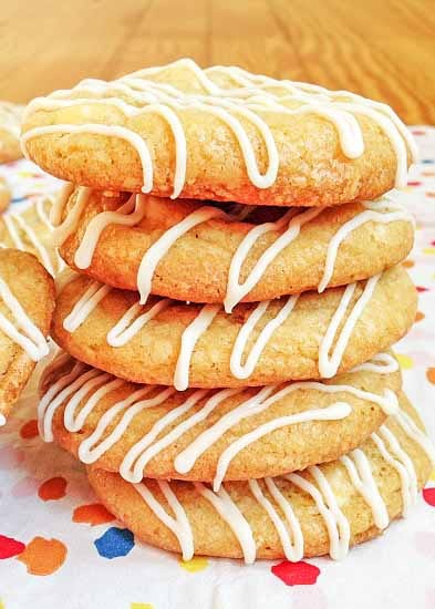 A close-up photo of five lemon cookies with white chocolate chips that have been stacked vertically