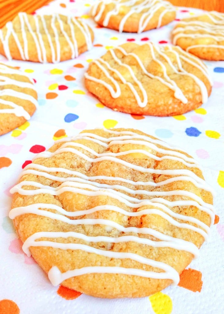 cookies with white icing are placed on a polka-dot napkin over a wooden tabletop