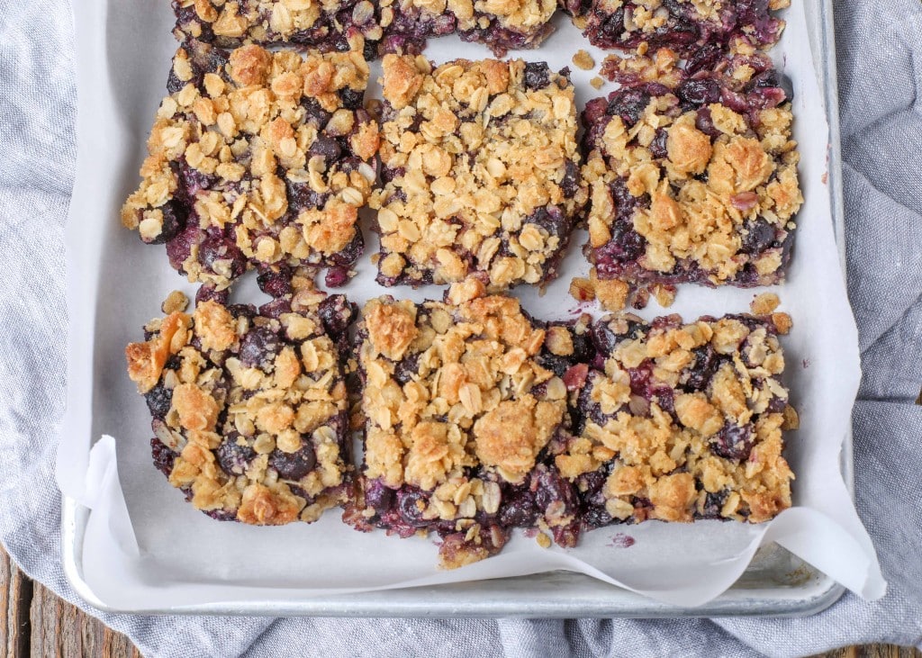 Blueberry crunch bars on metal tray with parchment