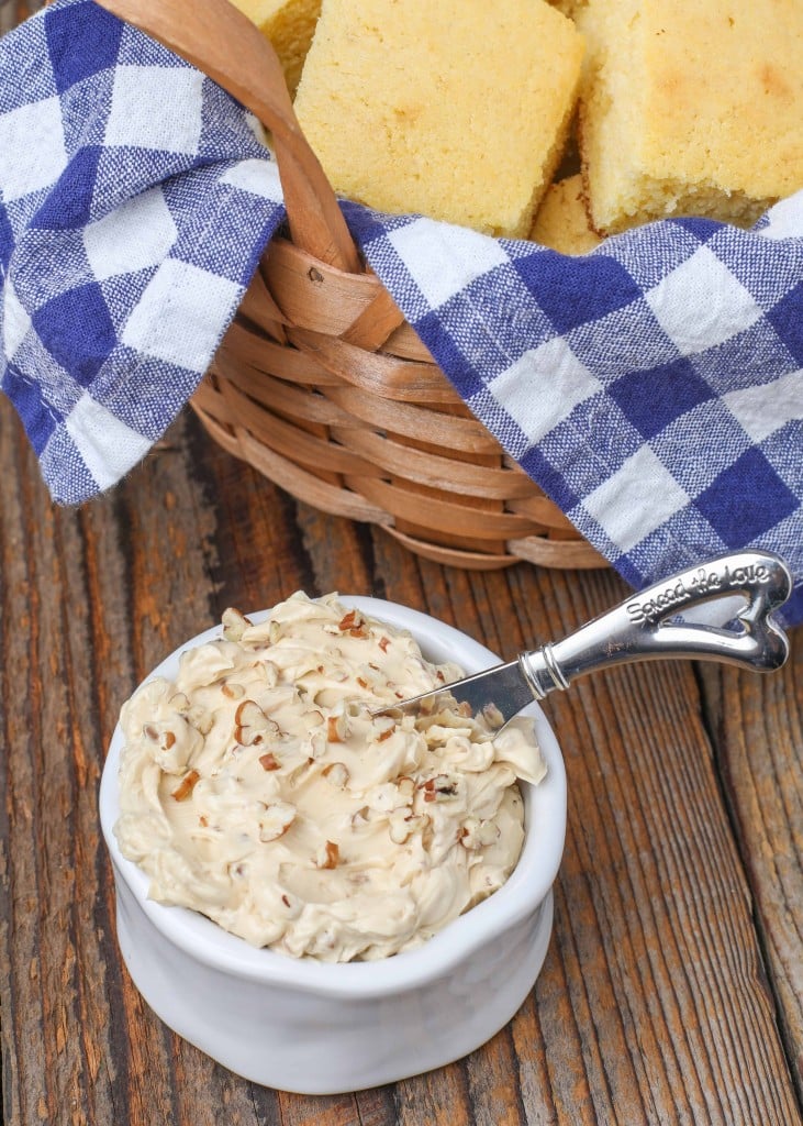 maple butter with pecans in white bowl next to cornbread