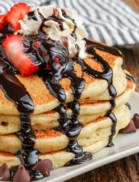 pancakes with chocolate chips, chocolate syrup, whipped cream, and berries