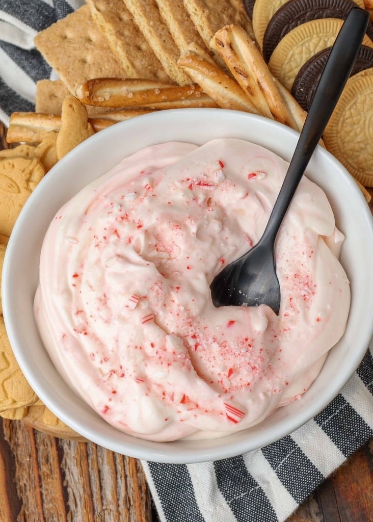 creamy candy cane dip with small black spoon in white bowl