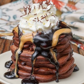 Chocolate pancakes with peanut butter and chocolate sauce and whipped cream on top