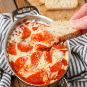 Pepperoni Pizza Dip with crostini and black and white towel