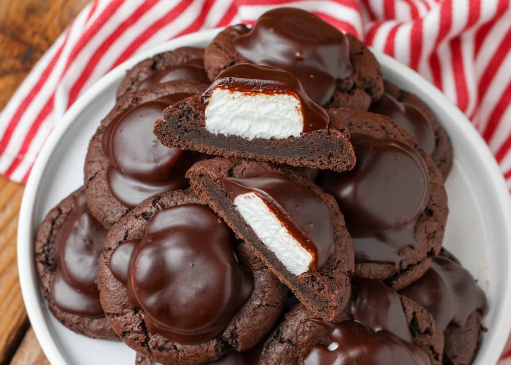 Chocolate Covered Marshmallow Cookies piled on a white plate with red and white striped linen