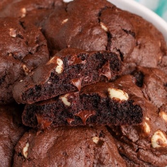 a close up shot of a halved chocolate cookie with white and dark chocolate morsels visible within