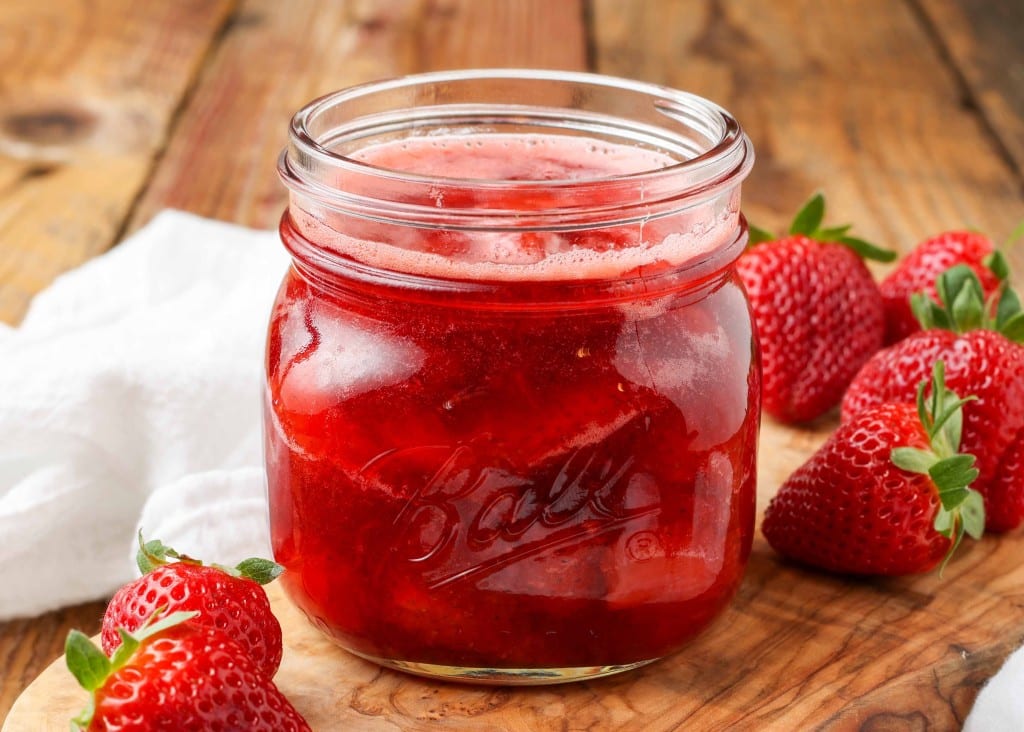 Strawberry Compote in glass jar with spoon