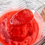 Strawberry Coulis in glass bowl with spoon and blue and white linen