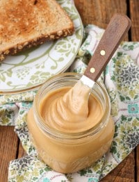 peanut butter mixture in jar with knife next to toast