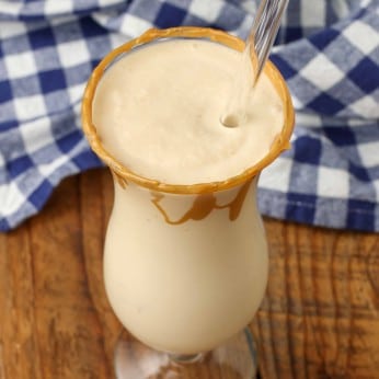 milkshake in tall curvy glass with straw and blue checked napkin