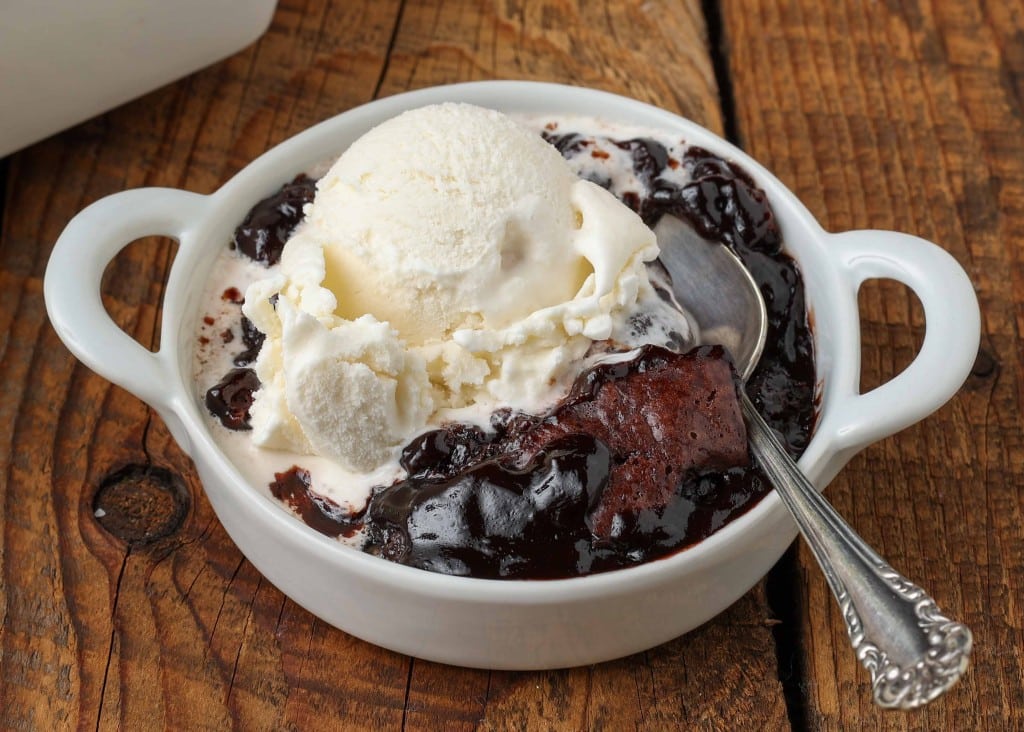 gooey chocolate filling under cobbler crust in white dish with ice cream 
