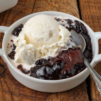 gooey chocolate filling under cobbler crust in white dish with ice cream