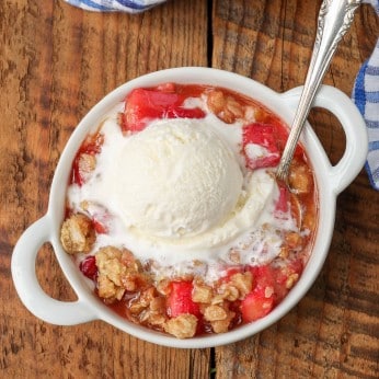 dish of rhubarb crisp with spoon next to blue napkin