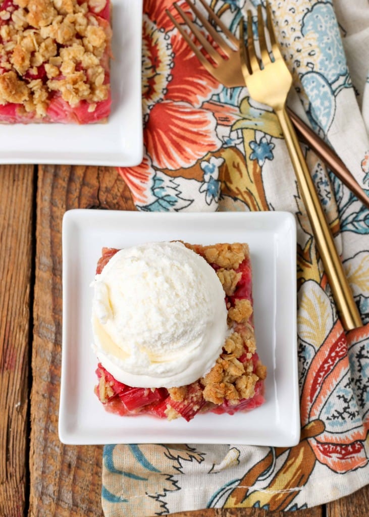 Rhubarb Oatmeal Bars topped with Ice Cream on small square plates