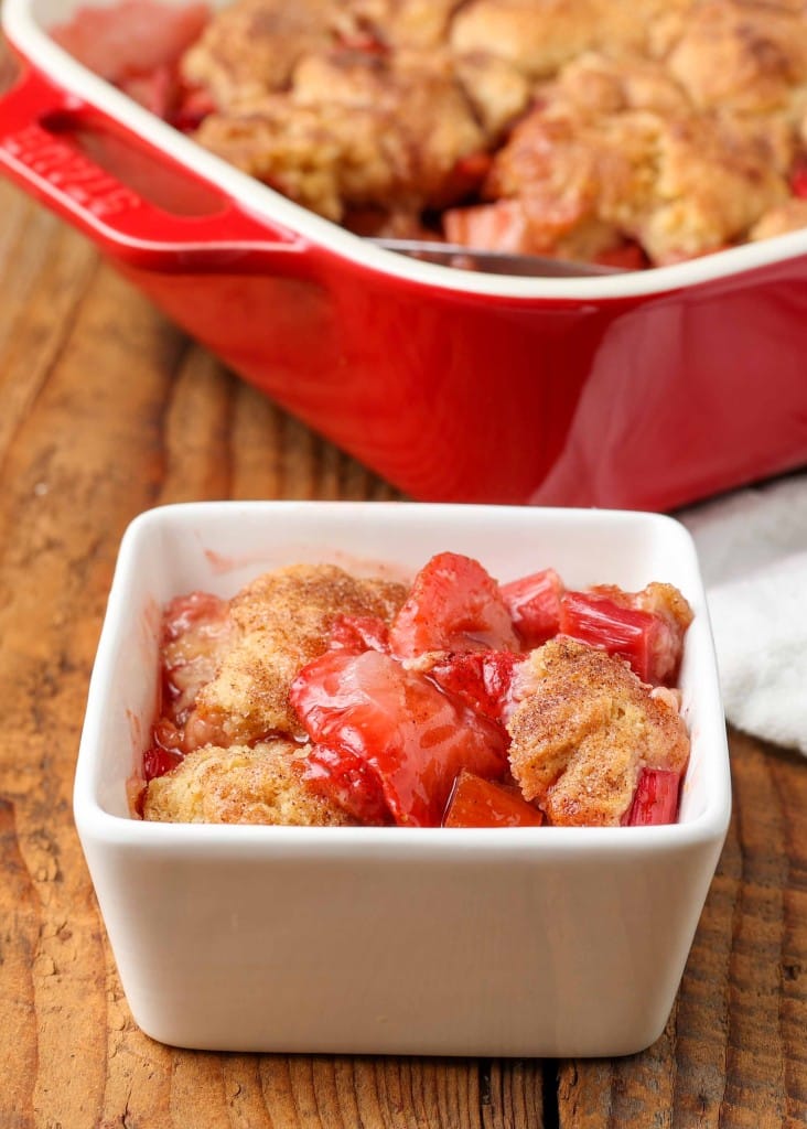a serving of strawberry rhubarb cobbler in a white square dish