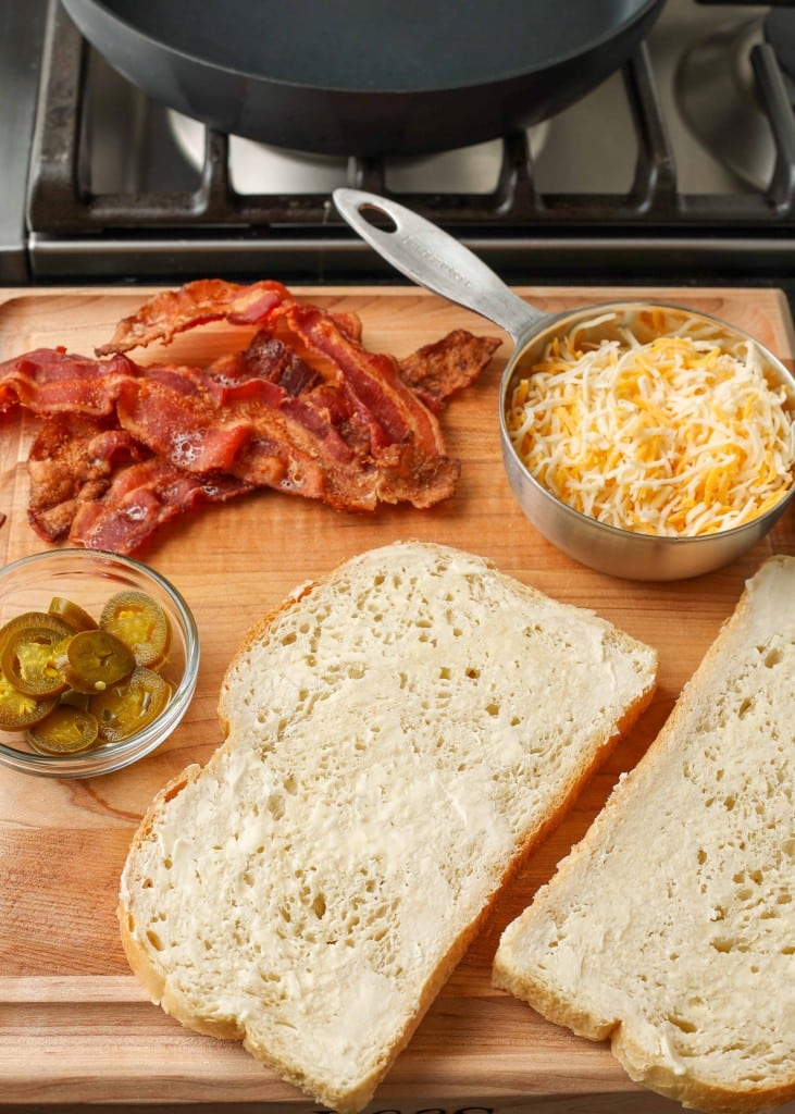 All of the ingredients to make this grilled cheese sandwich have been arranged on a wooden serving tray