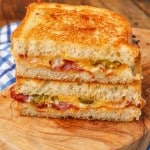 the bacon grilled cheese has been sliced in half and stacked on top of each other
