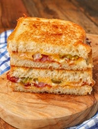 the bacon grilled cheese has been sliced in half and stacked on top of each other