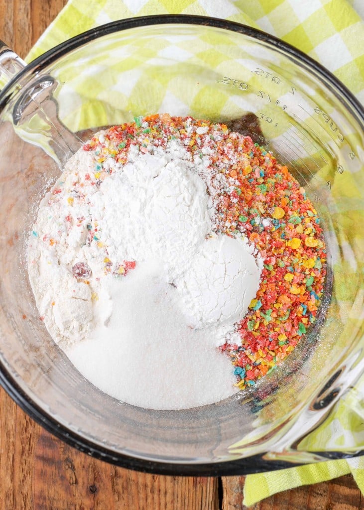 Overhead shot of fruity pebbles cereal and other dry baking ingredients in a glass bowl