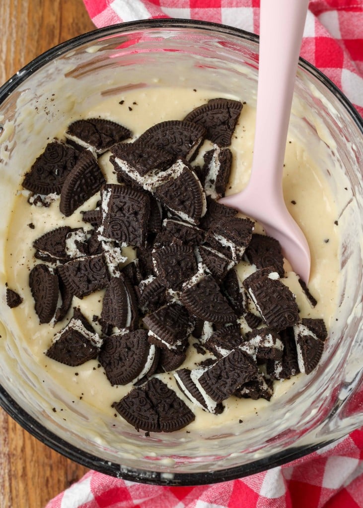 Stirring the oreo pieces into the pancake batter in a glass mixing bowl