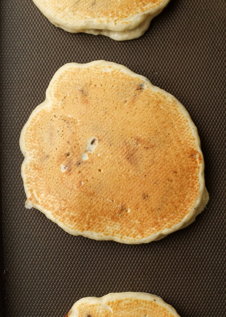 The oreo pancake has been flipped and is a beautiful shade of golden brown atop a grey griddle