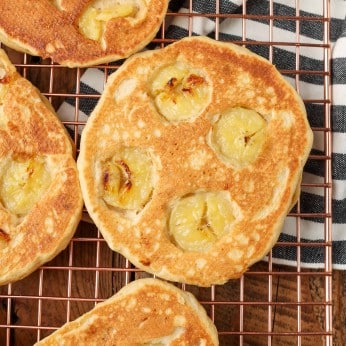 peanut butter pancakes with sliced bananas on cooling rack