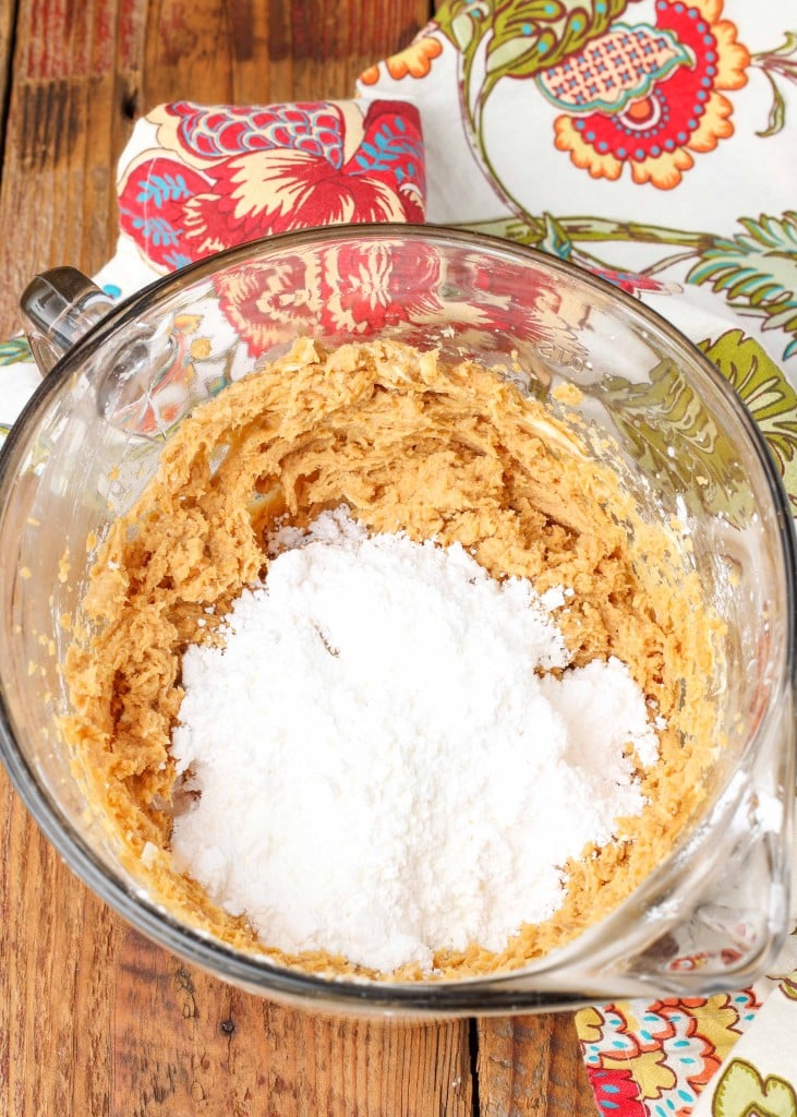 Overhead shot of white sugar and combined peanut butter and butter in a glass bowl