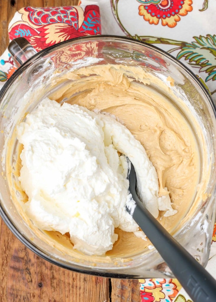 Peanut butter, sugar, white sugar, and heavy cream, combined in a glass bowl