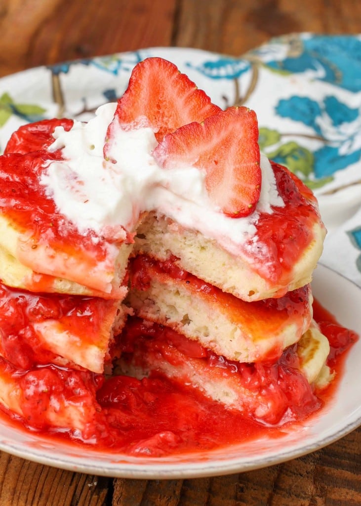 stacked pancakes with strawberry sauce between the layers