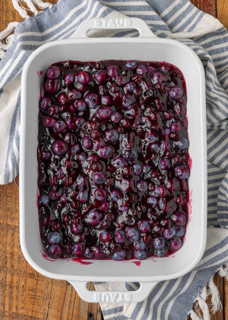 the blueberry filling has been added to a white rectangle baking dish, ready to be topped and baked in the oven.