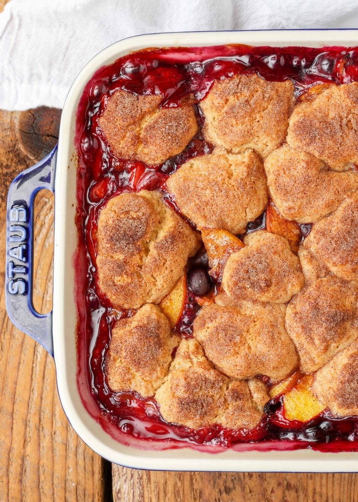 a shot of the blueberry peach cobbler, ready to serve, in a white baking dish