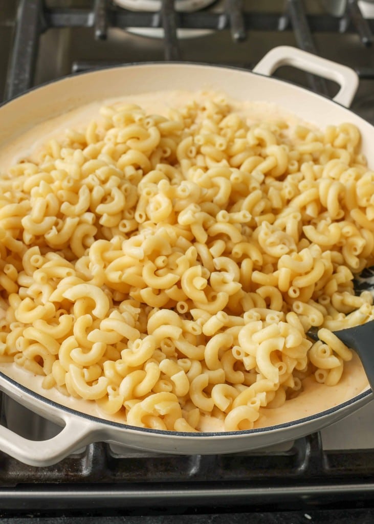 Noodles have been added to the pan of creamy, cheesy sauce.