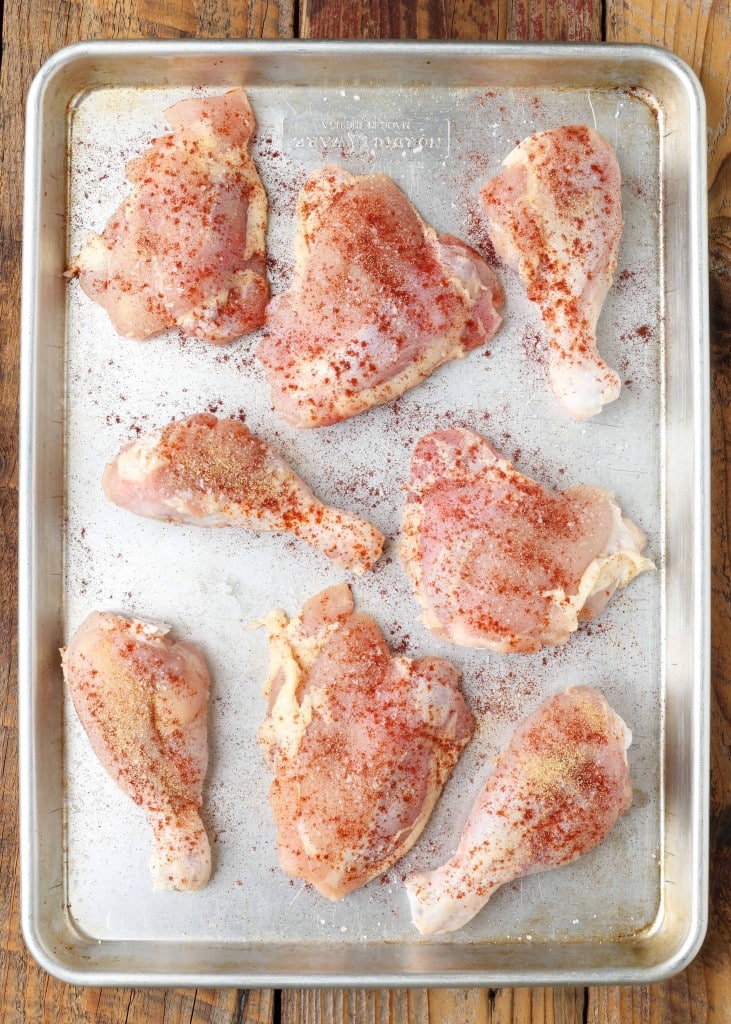 Overhead vertical shot of lightly seasoned chicken in a sheet pan