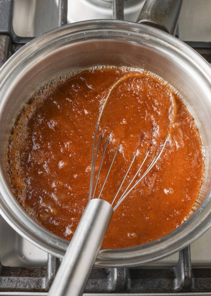 Overhead shot of melted butter and brown sugar in saucepan with silver whisk