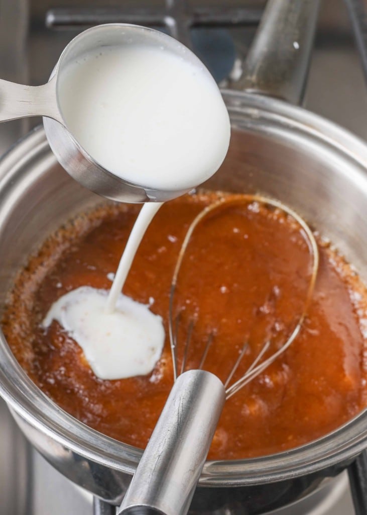 Overhead shot of buttermilk mid-pour over saucepan with melted butter and brown sugar