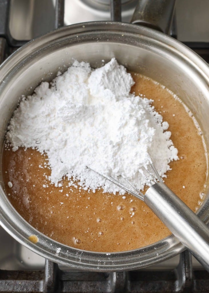 Overhead shot of melted butter, brown sugar, buttermilk, and powdered sugar in a saucepan
